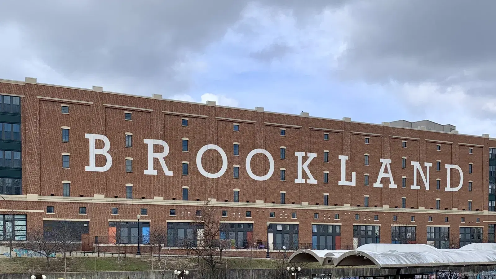The BROOKLAND wordmark painted across the brick facade of the Brookland Arts Walk building above the Brookland–CUA Metro station, Washington, D.C.