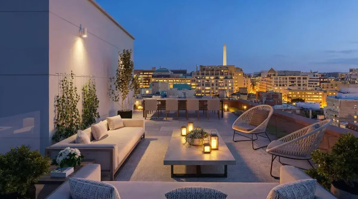 Rendering of the 14Church roof deck at dusk with sofas, a dining table and the Washington Monument on the skyline