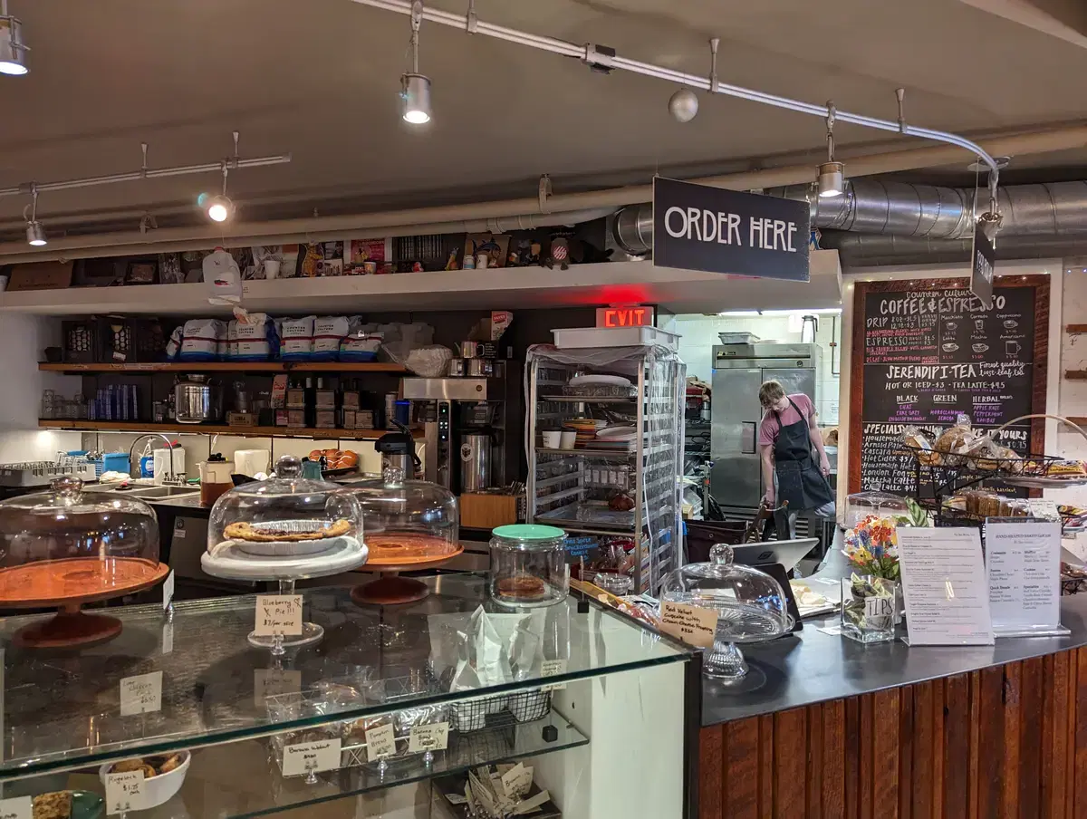 Interior of the Politics & Prose cafe (The Den): counter, pastry cases, chalkboard menus