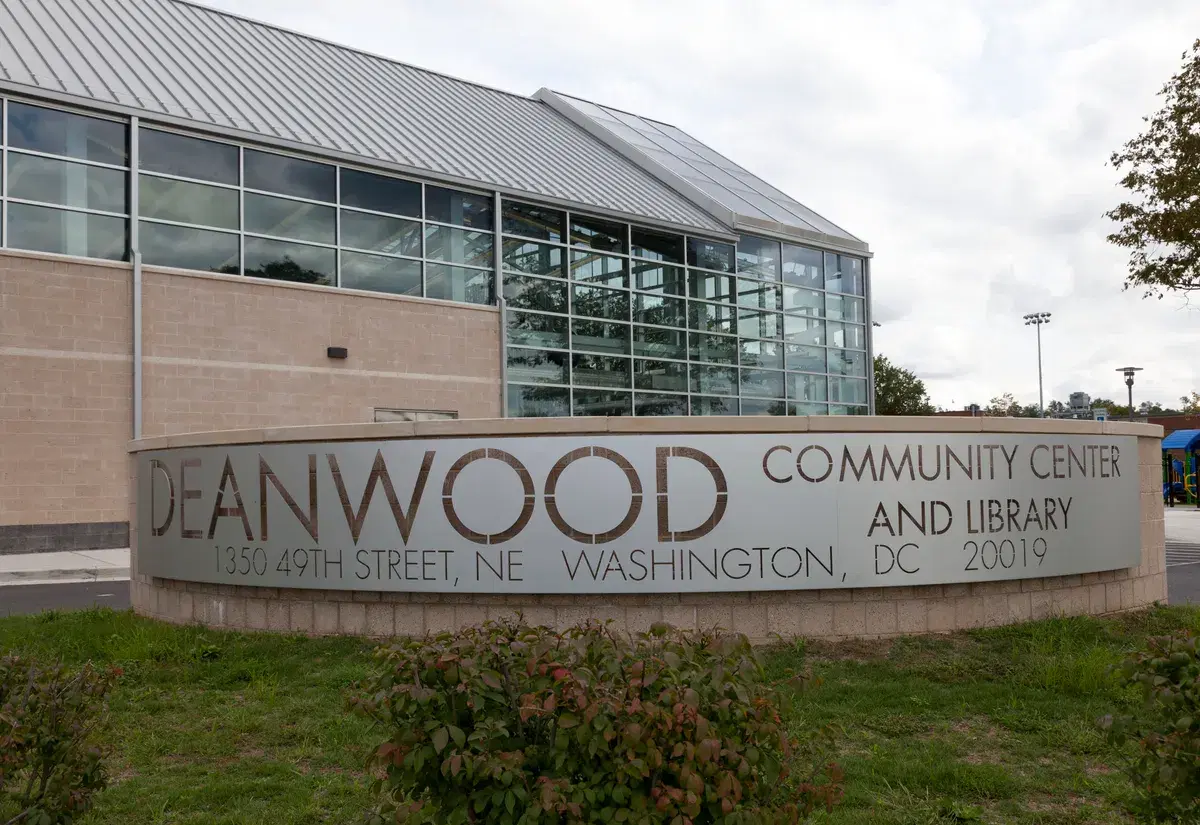 The Deanwood Community Center and Library sign in front of the glass-walled building on 49th Street NE
