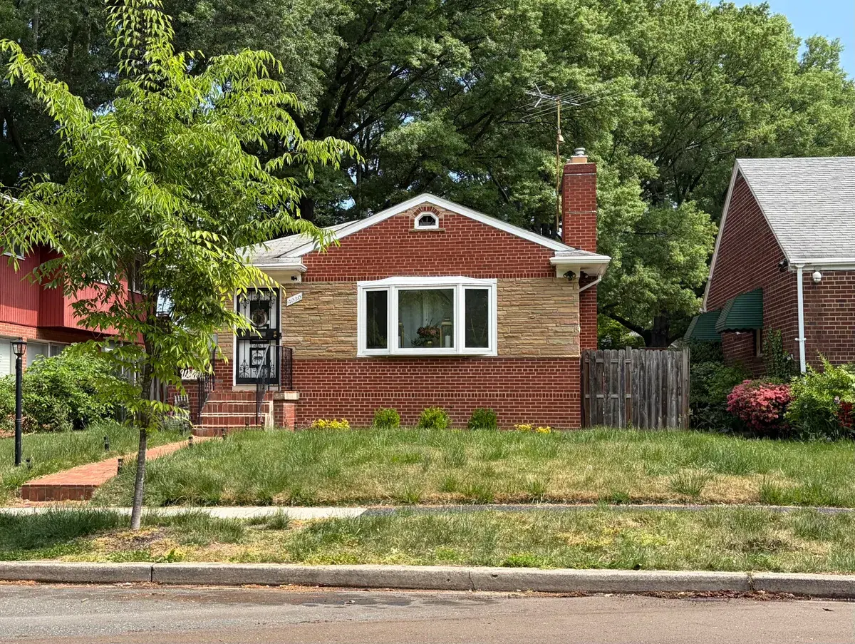A red-brick bungalow with a bay window and stone band on a lawn in Eastland Gardens