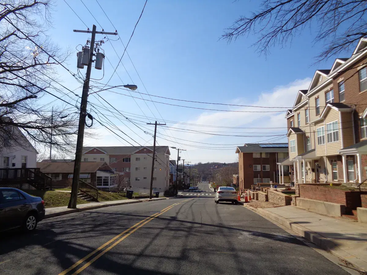 A hilly street at 50th and C Streets SE, with new townhouses on the right and apartments beyond