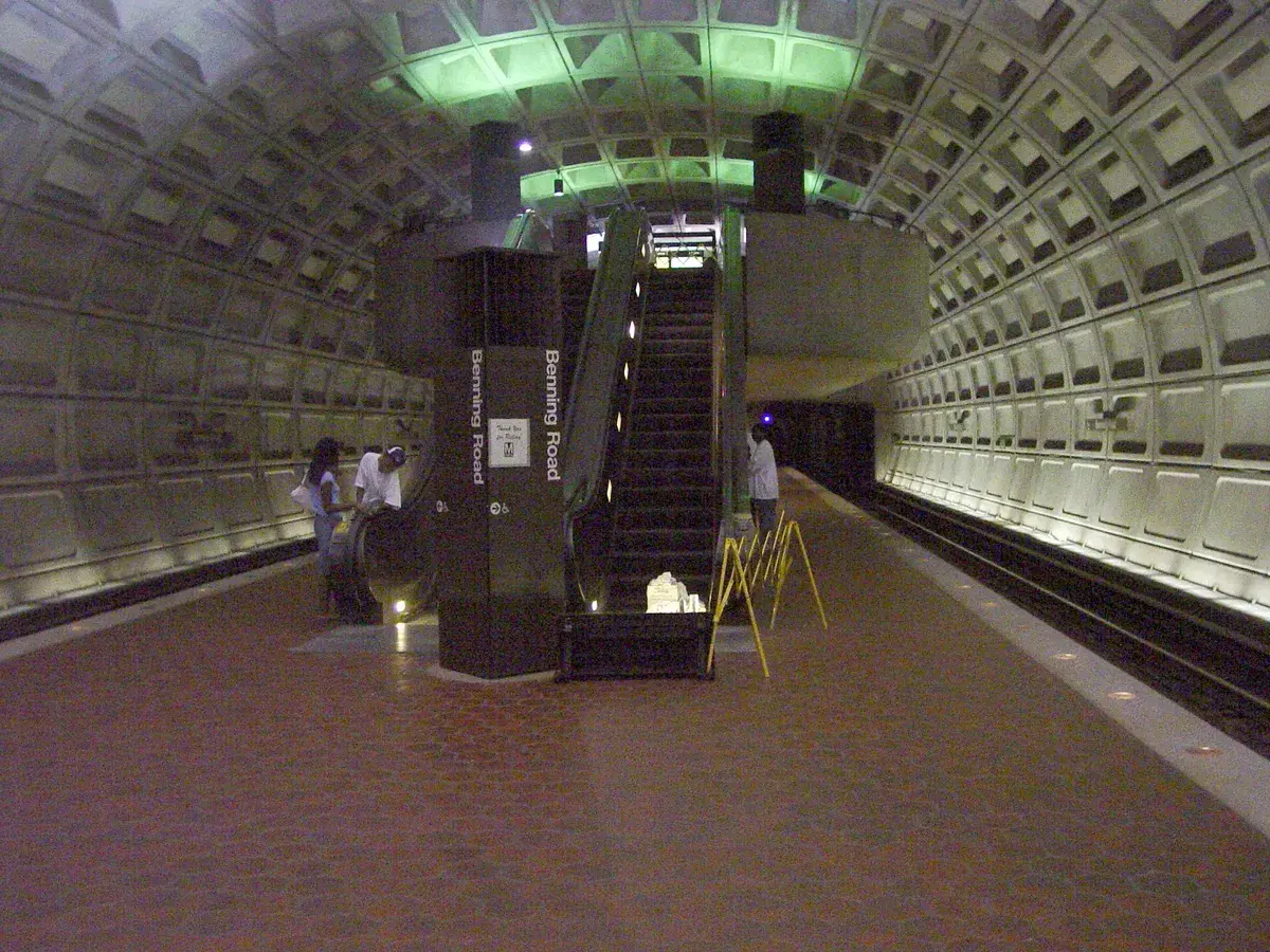 The Benning Road station platform, with the station name on a pylon beside the escalator