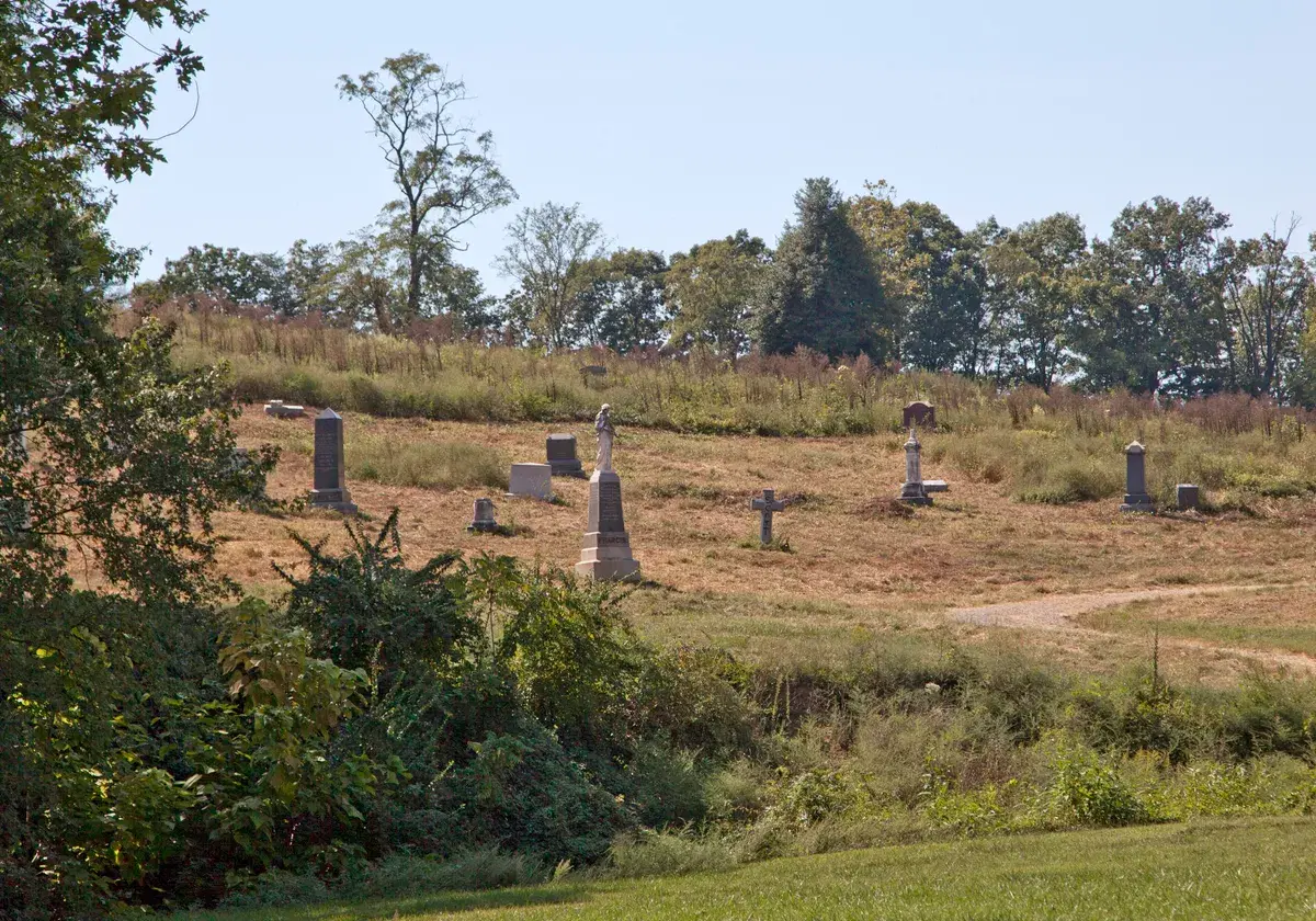 Headstones on a grassy hillside at Woodlawn Cemetery on Benning Road