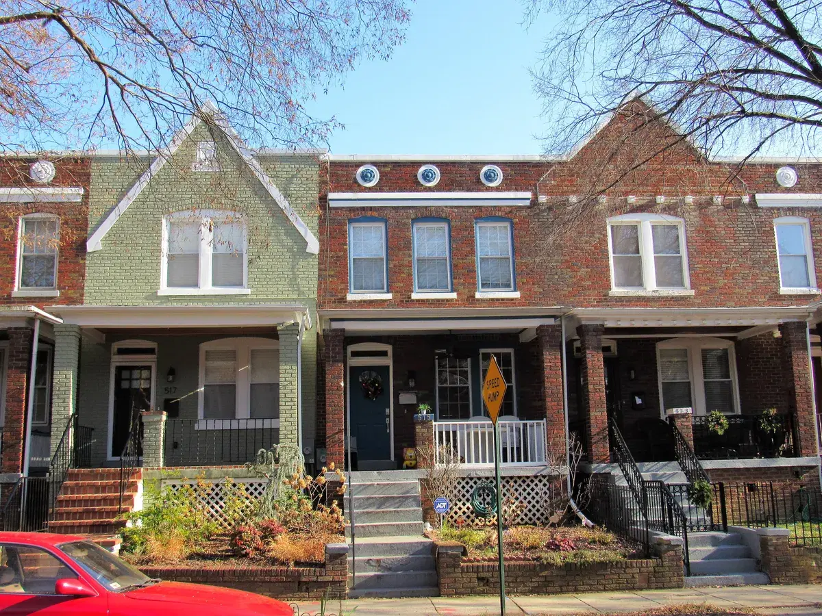 A row of brick rowhouses with front porches in Kingman Park