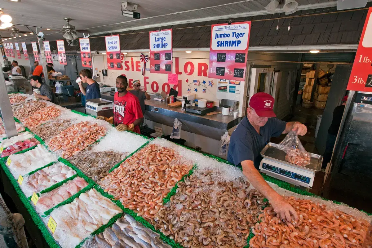 A seafood stall piled with fresh fish and shrimp on ice at the Maine Avenue Fish Market, Washington, D.C.