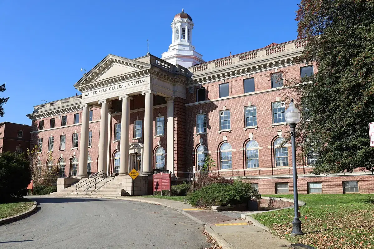 The columned facade and cupola of Walter Reed's historic Building 1 under a deep blue sky, Washington, D.C.