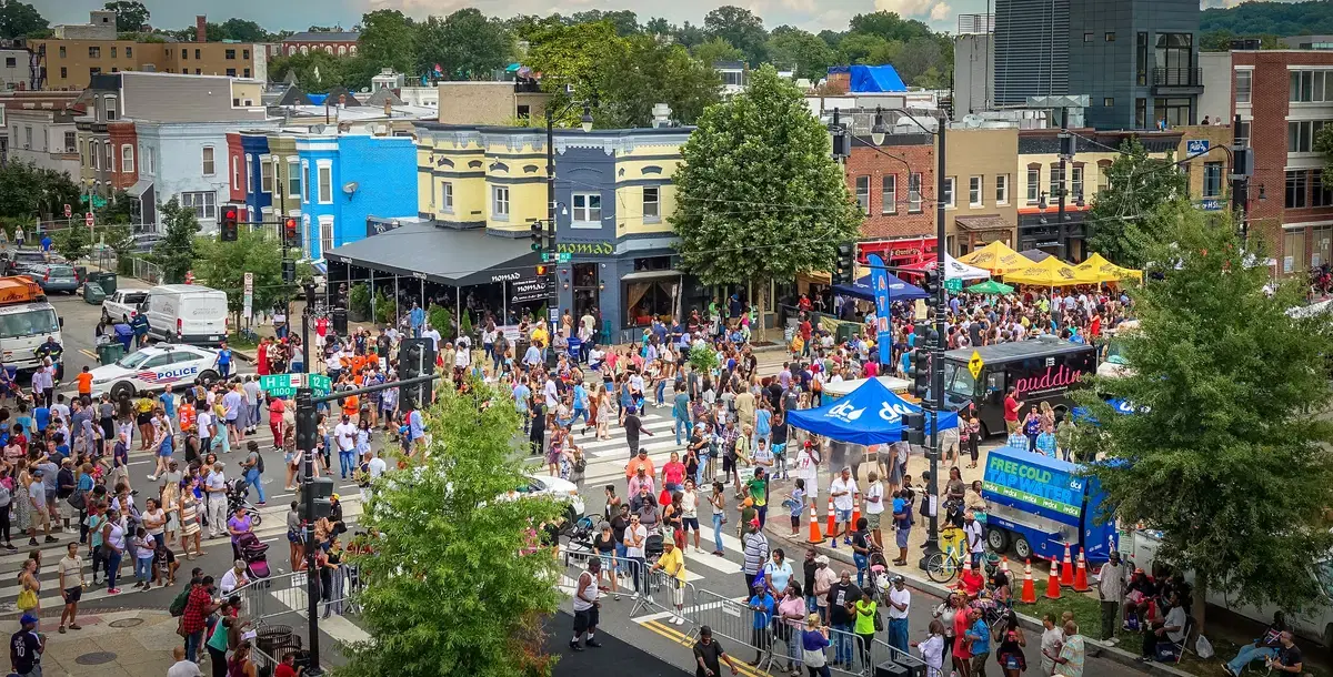 Festival crowds, tents, and painted rowhouse storefronts at the H Street Festival at H and 12th Streets NE, Washington, D.C.