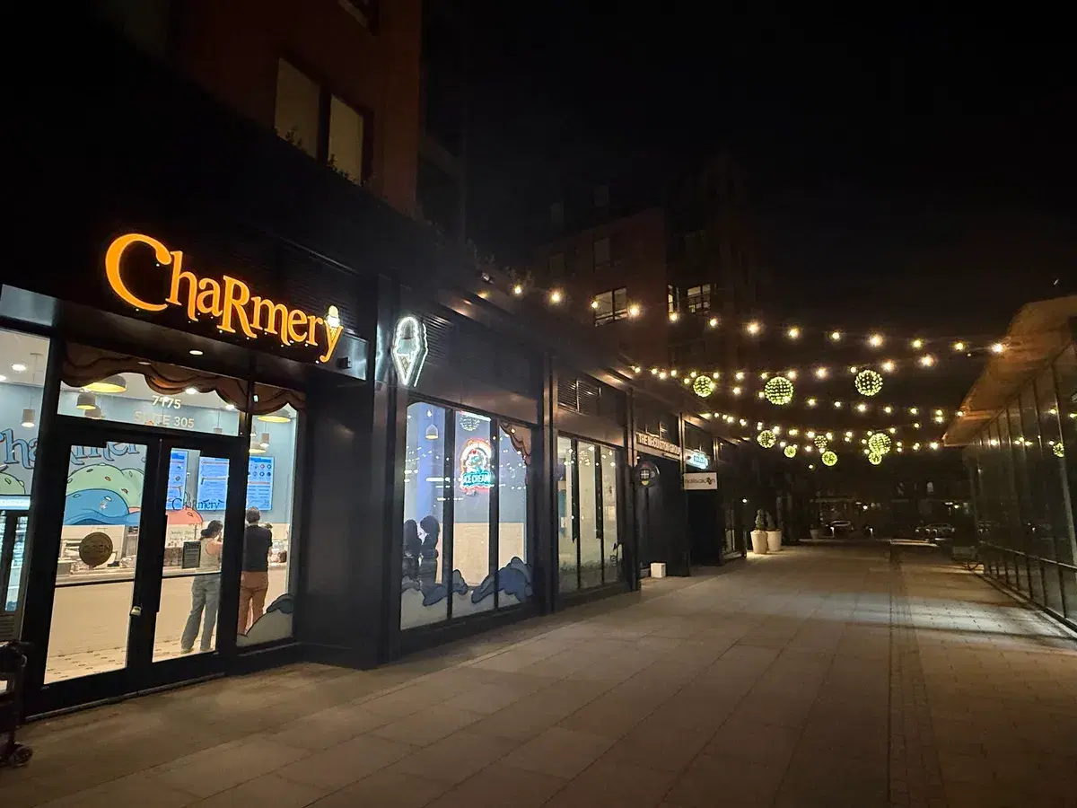The Charmery ice cream shop lit up at night under string lights
