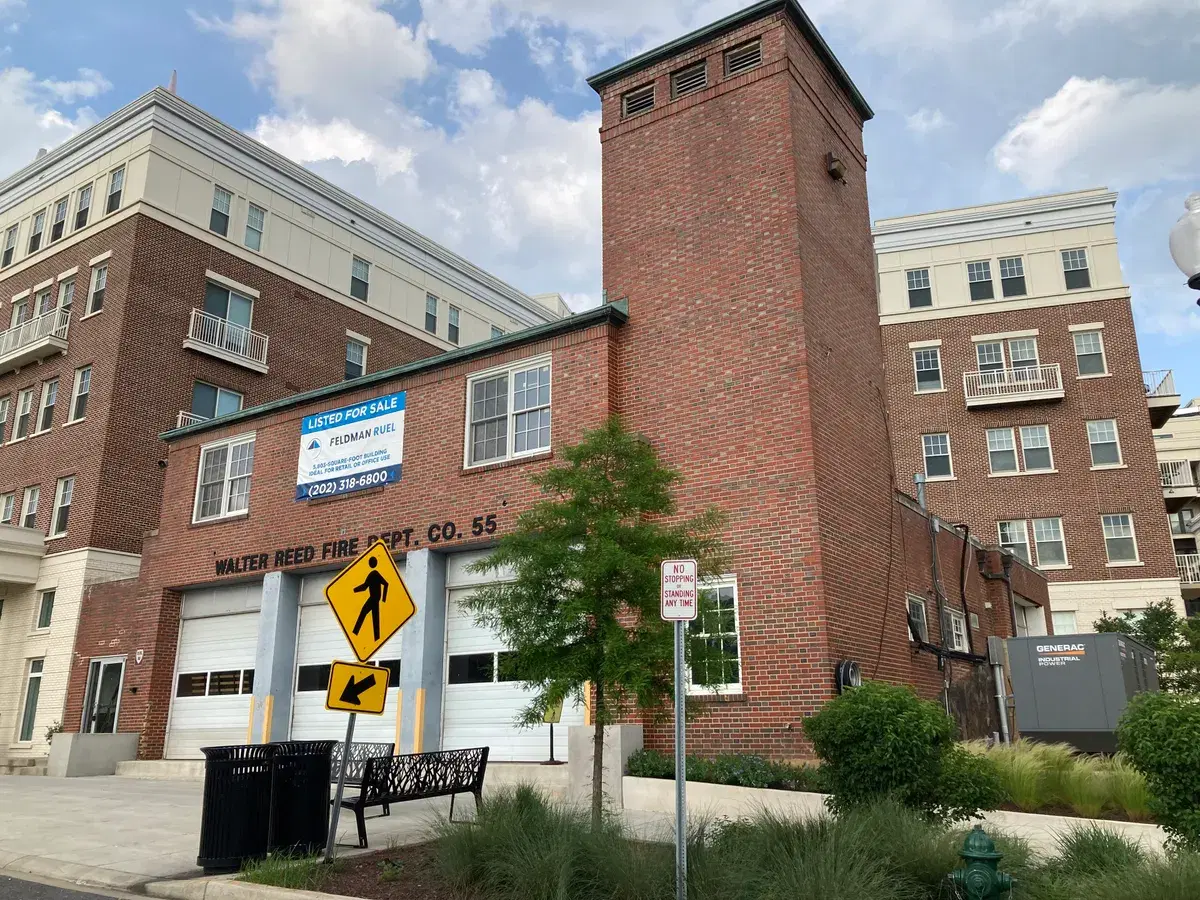 The former Walter Reed Fire Dept. Co. 55 brick firehouse between two new apartment buildings