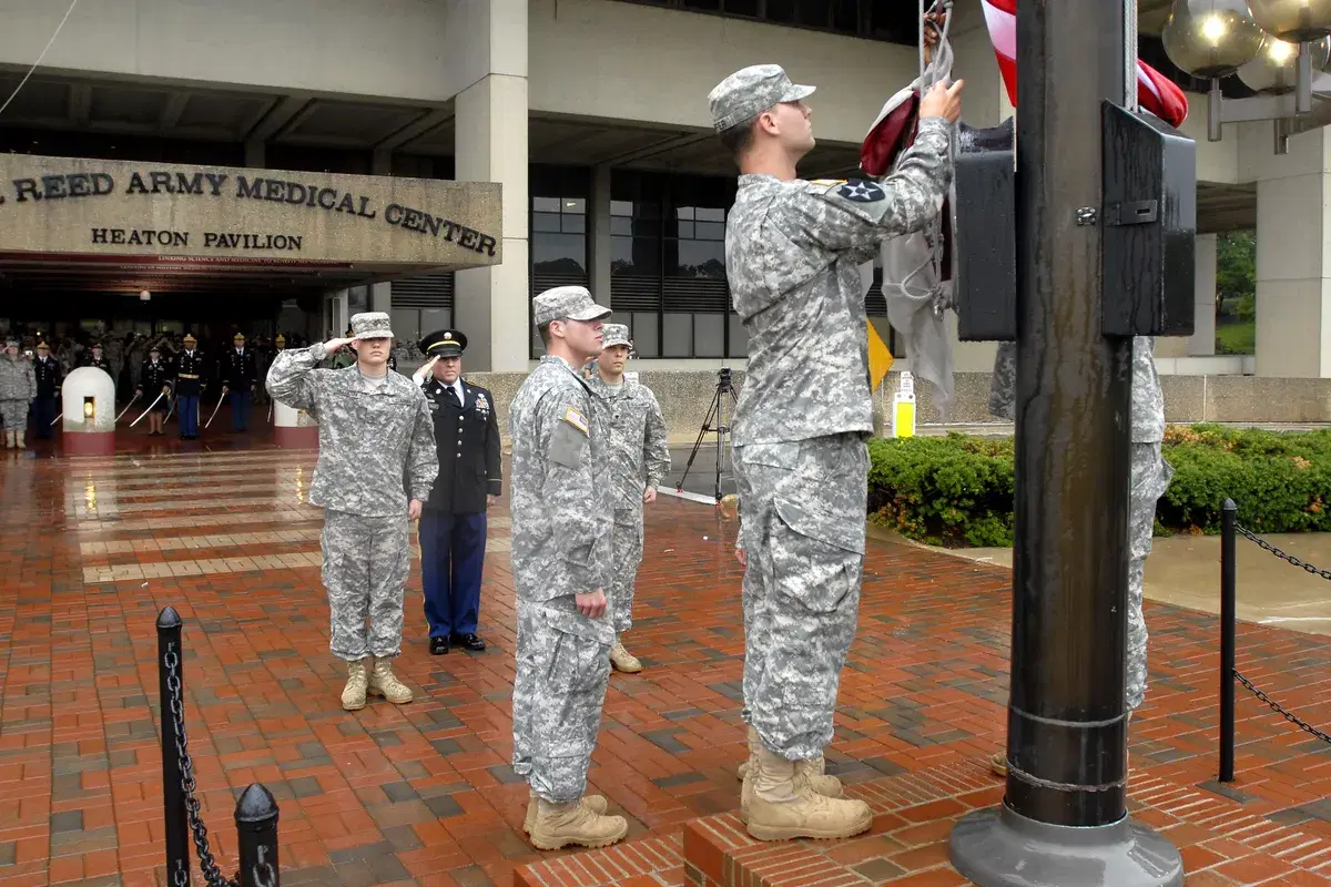 Soldiers salute as the U.S. flag is lowered outside the Walter Reed Army Medical Center's Heaton Pavilion