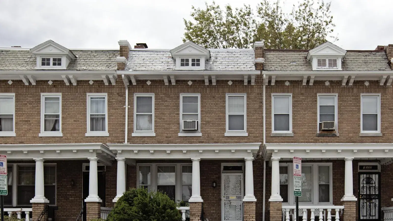 A row of porched brick rowhouses with dormer windows on Quincy Street NW, Washington, D.C.