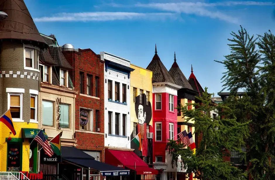 Actual 18th Street NW Adams Morgan — colorful turreted storefronts with flags, Mezè wine bar at 2433 18th St visible; Pexels alt confirms Adams Morgan