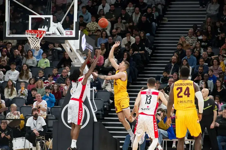 Pro basketball game timeout huddle with big engaged crowd - arena game-night ambience per brief; venue not identifiable, though European-league jerseys are visible at close inspection