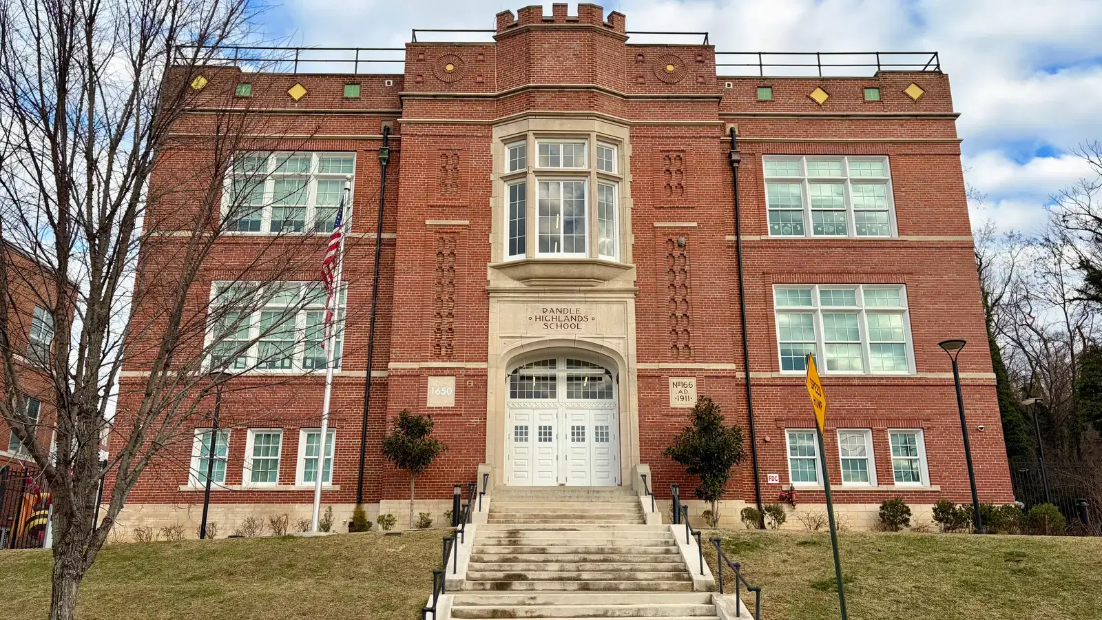 The 1911 Tudor Revival brick facade of Randle Highlands School, its name carved in stone above the arched entrance, Washington, D.C.