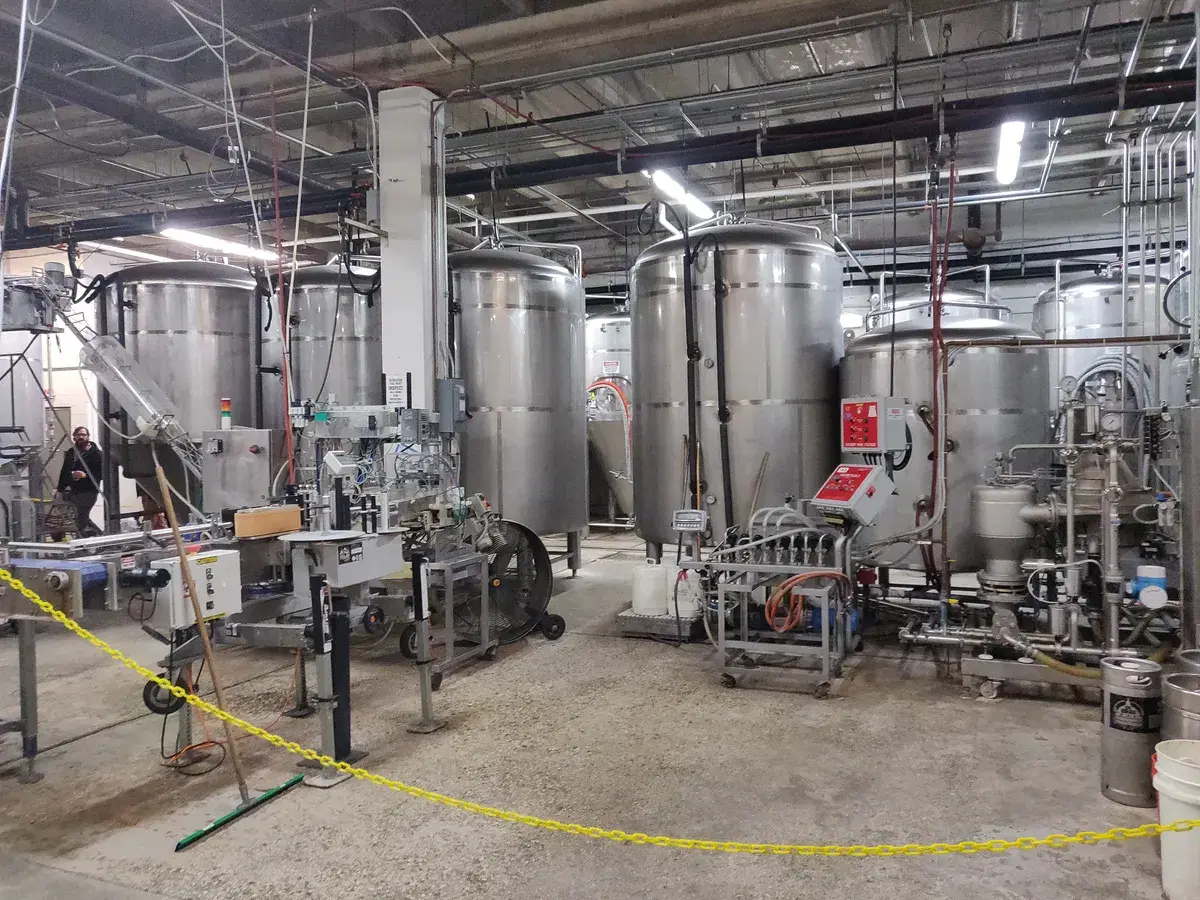 Steel fermenting tanks and a canning line inside the DC Brau brewery