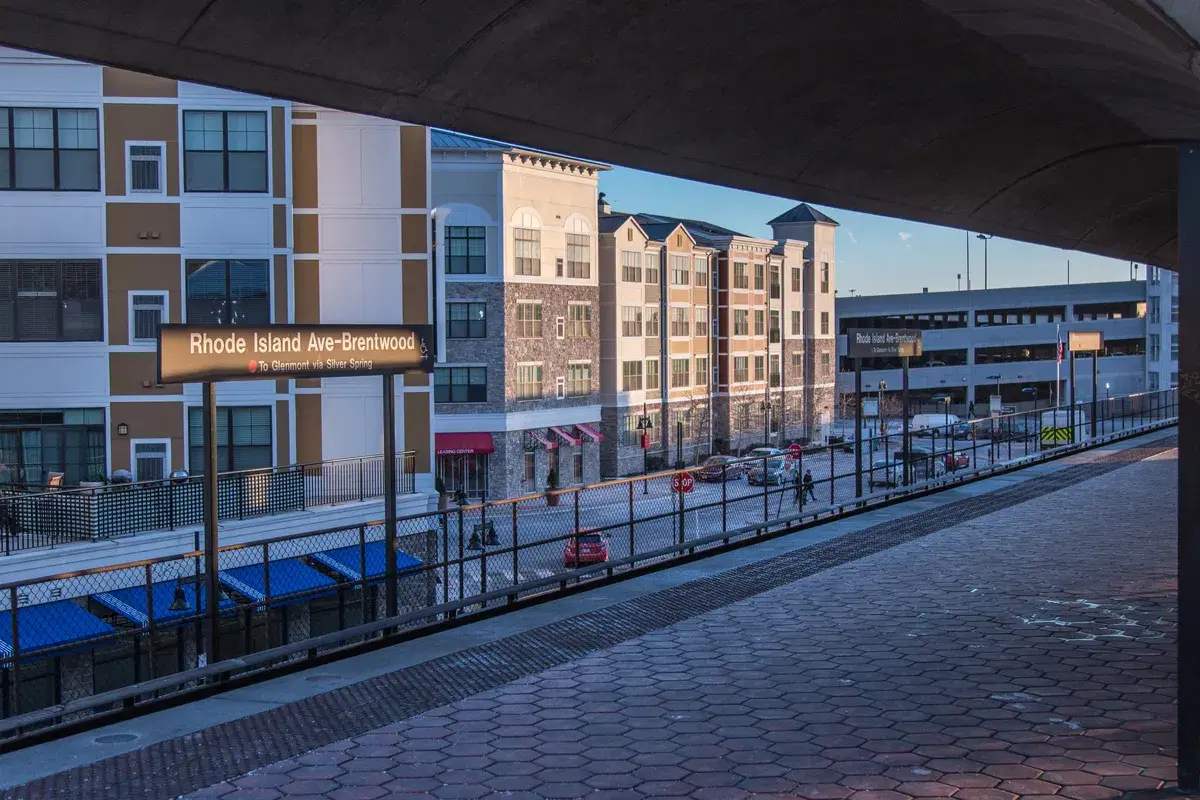 The platform and station sign at Rhode Island Ave-Brentwood Metro, with apartment buildings behind