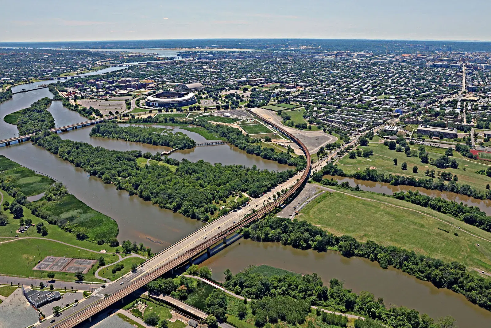 Aerial view over the Anacostia at the Benning Road bridge, with Kingman Lake, the RFK campus and Capitol Hill beyond
