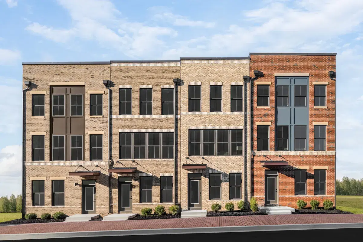 A row of four-story brick townhomes at Skyland with flat roofs and metal door canopies