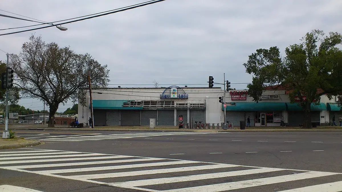 Storefronts of the former Skyland Shopping Center across a wide crosswalk