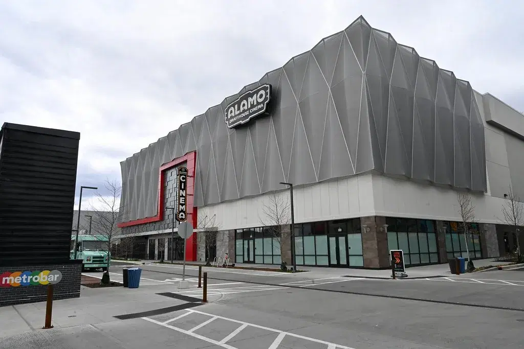 The Alamo Drafthouse Cinema at Bryant Street, a gray folded-metal building with a red entrance and a vertical Cinema sign