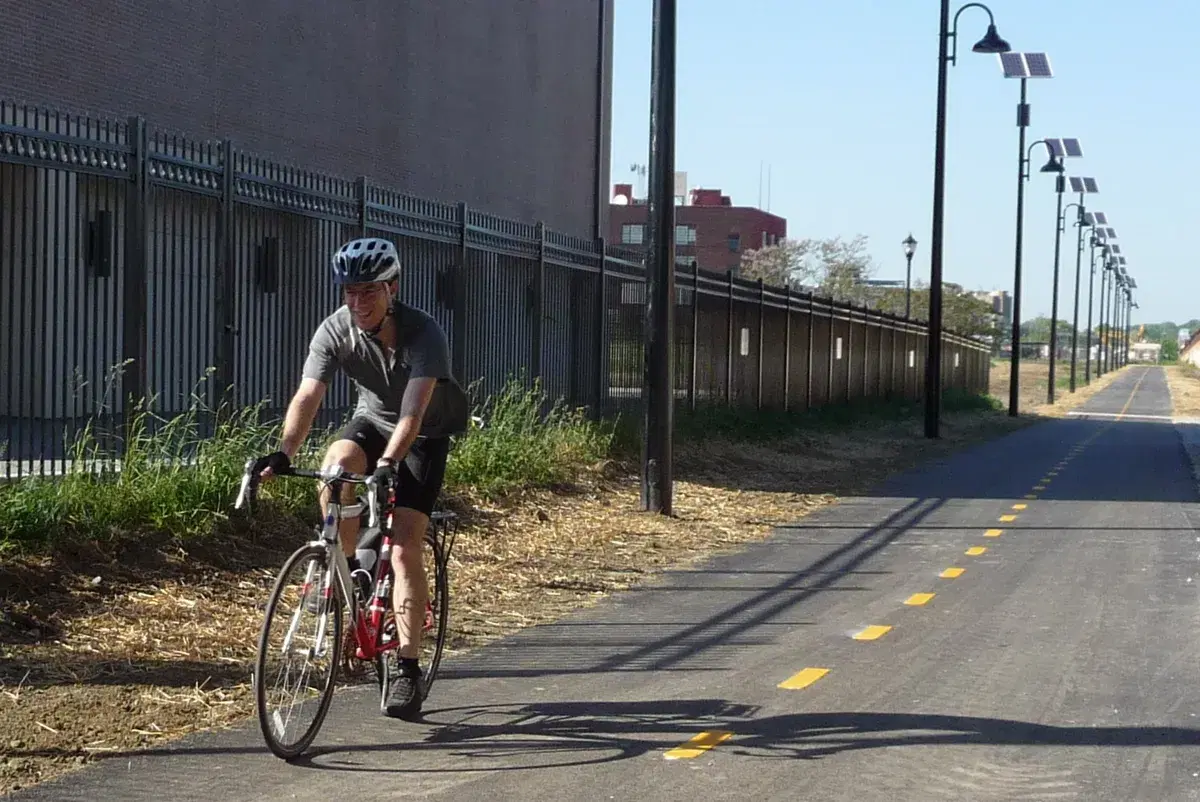 A cyclist on the Metropolitan Branch Trail, lined with solar-powered lamps