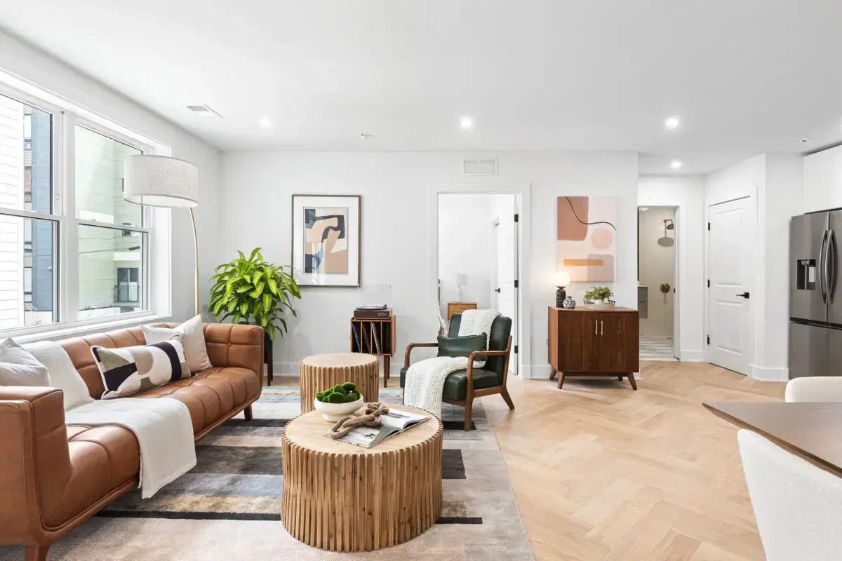 Living room in a condo at the Sidney, with herringbone oak floors and doors to a bedroom and bath