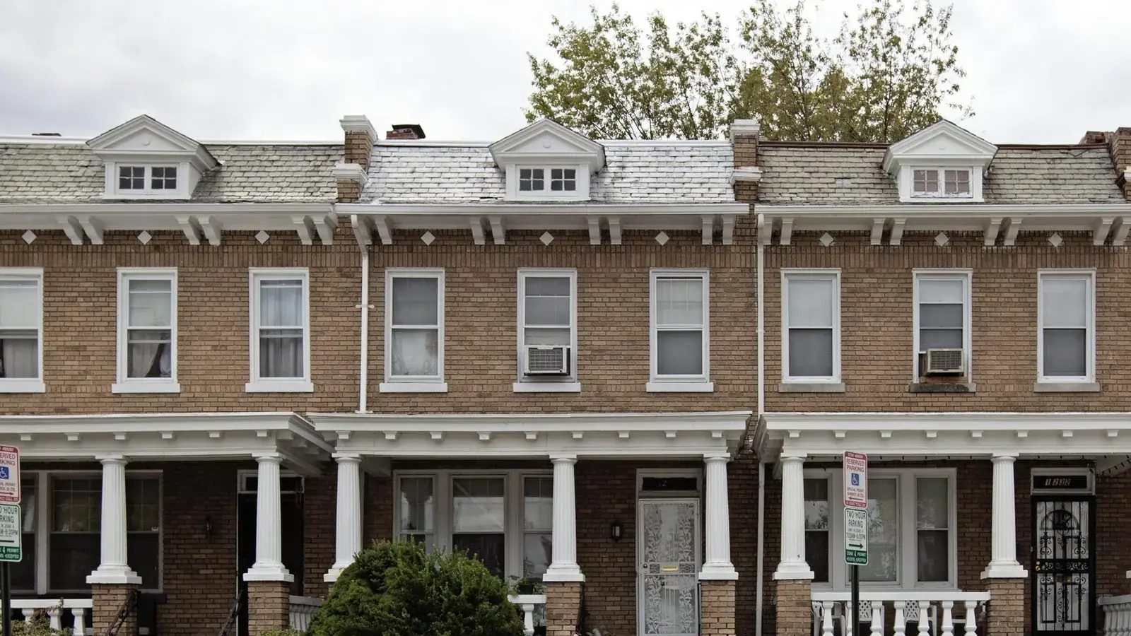 A row of porched brick rowhouses with dormer windows on Quincy Street NW, Washington, D.C.