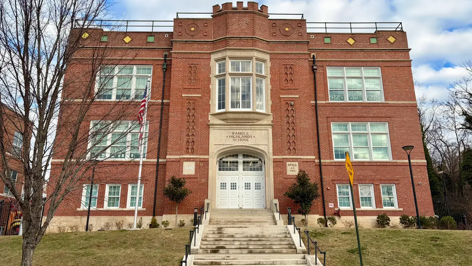 The 1911 Tudor Revival brick facade of Randle Highlands School, its name carved in stone above the arched entrance, Washington, D.C.