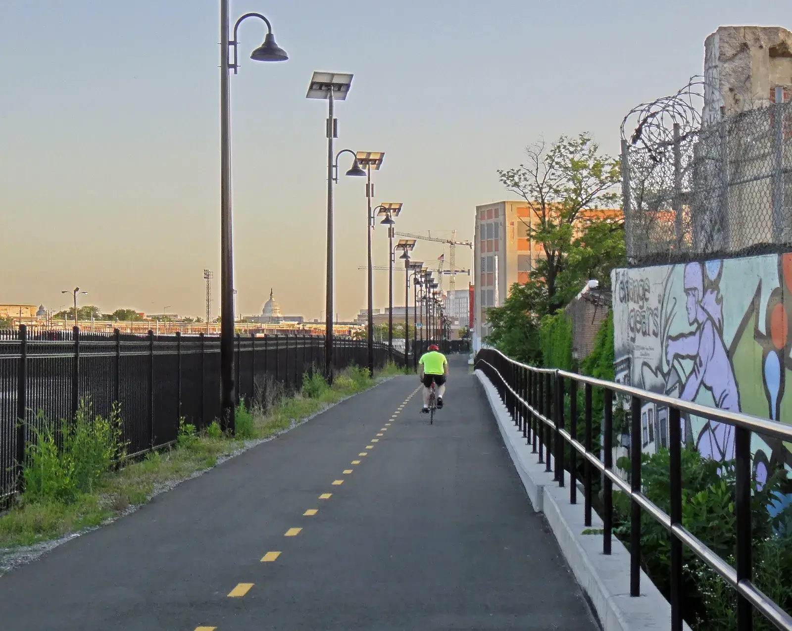 A cyclist on the Metropolitan Branch Trail with the Capitol dome in the distance