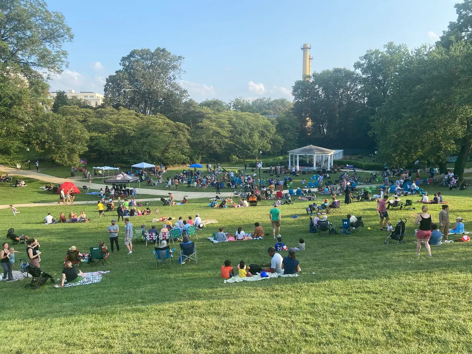 Crowds on blankets and lawn chairs at a summer concert on the Great Lawn